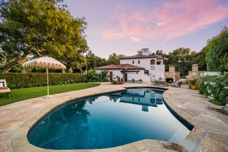 Vista al patio de casa blanca con alberca.